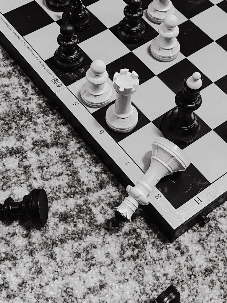 Close-up black and white chess pieces in strategic game position on board.