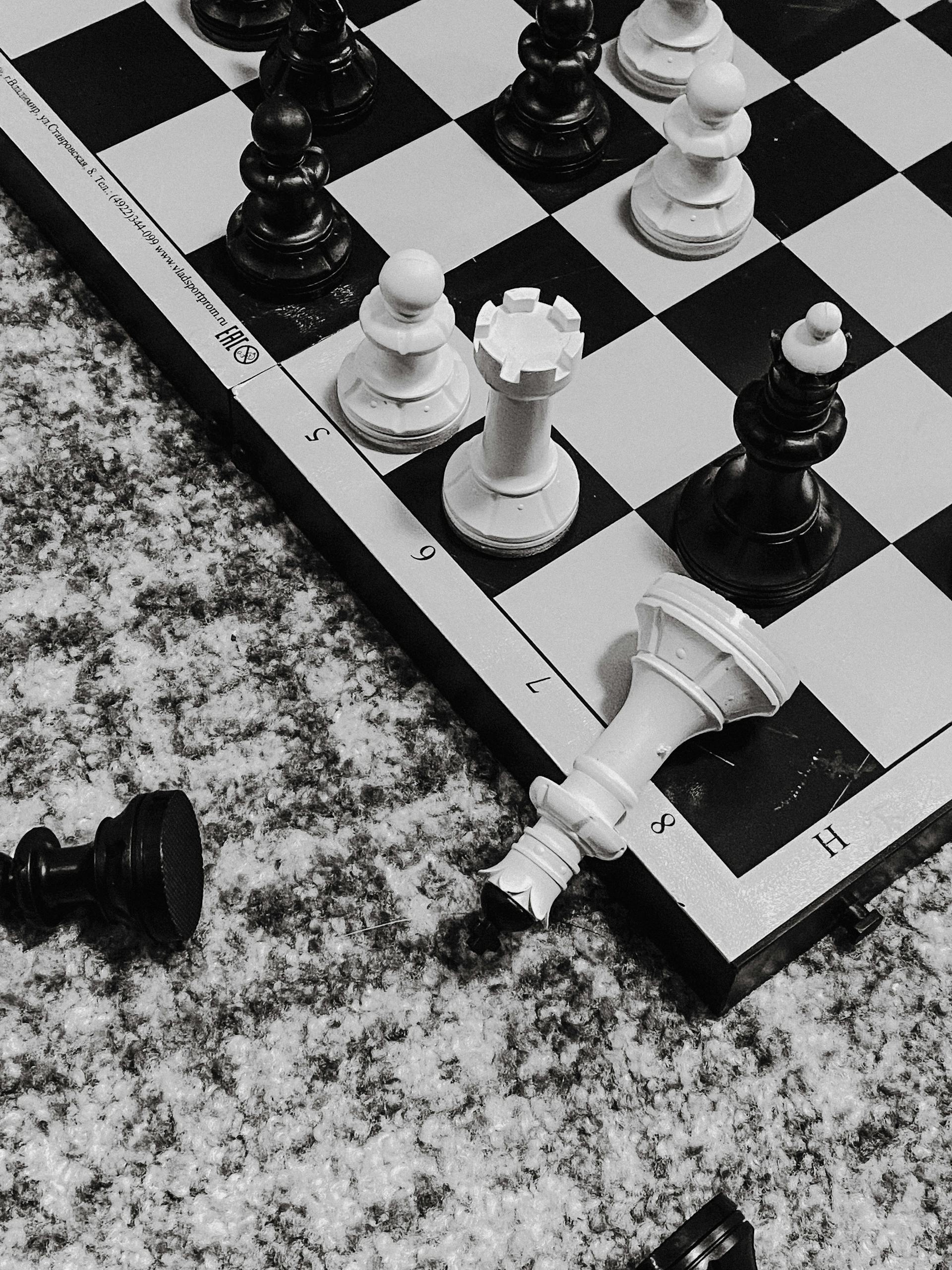 Close-up black and white chess pieces in strategic game position on board.